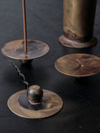 Hand-forged brass incense burners by 13 Knives Melbourne with heat patina and spherical bases, shown in a black tabletop detail shot