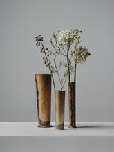 Set of three handcrafted brass vases by 13 Knives Melbourne Australia holding seasonal flowers on a minimal backdrop