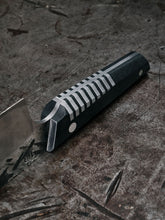 detail shot of a hand forged chef knife with silver inlays in the handle